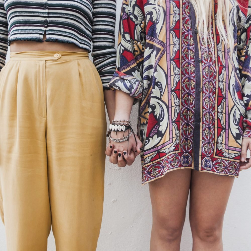 midsection-trendy-sisters-holding-their-hands